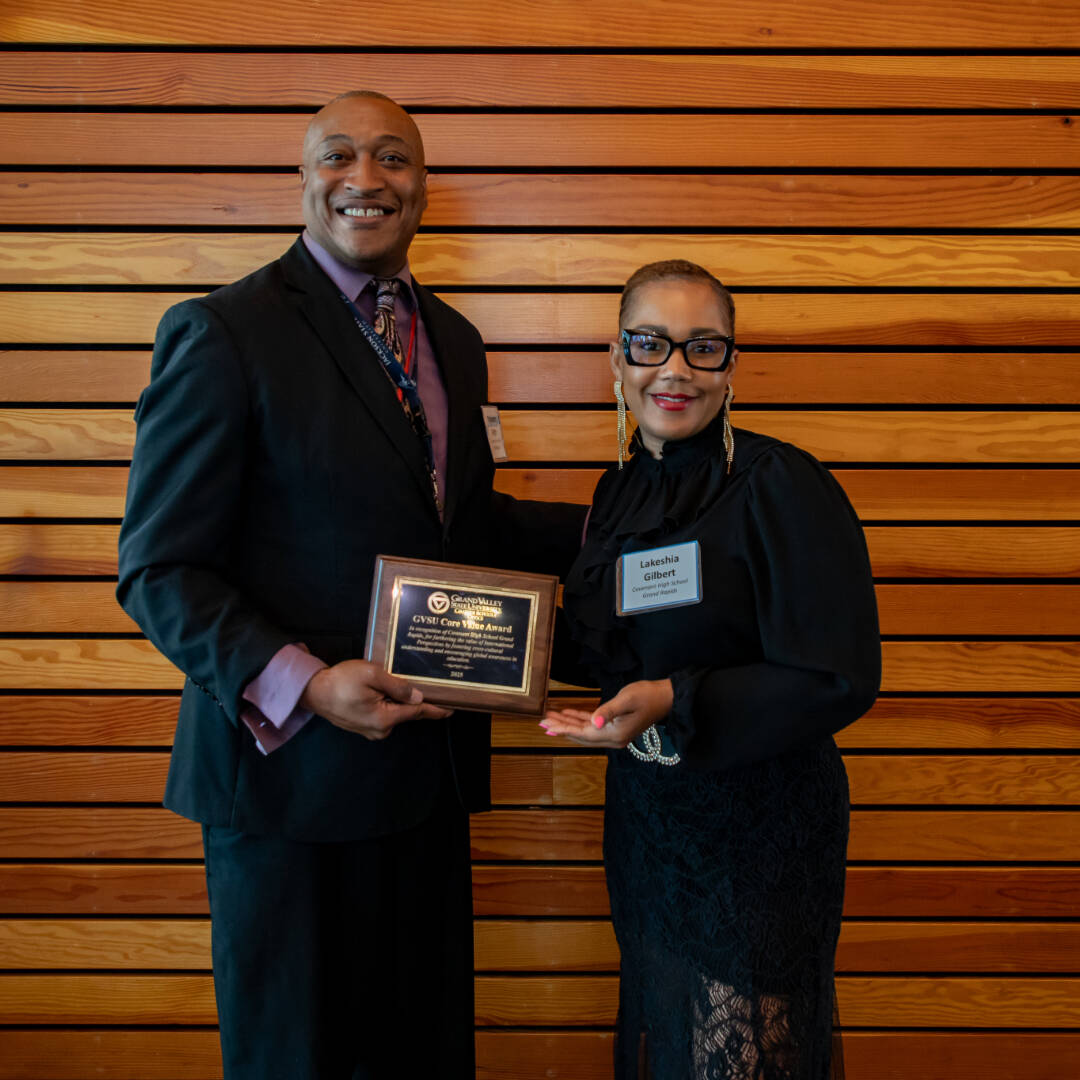 A school principal and a board member pose while holding the Core Values Award plaque they had just received.